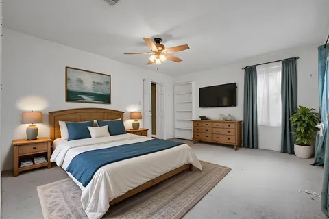 a bedroom with bed a flat tv and a couch