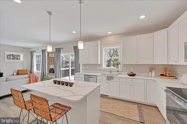 a kitchen with stainless steel appliances a sink a stove a refrigerator a center island and furniture