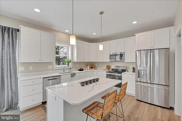 a kitchen with a refrigerator a white stove top oven a sink dishwasher and a refrigerator with wooden floor