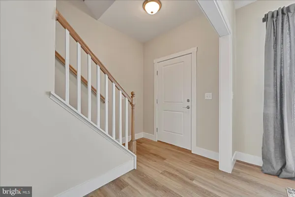 a view of a hallway with wooden floor and staircase