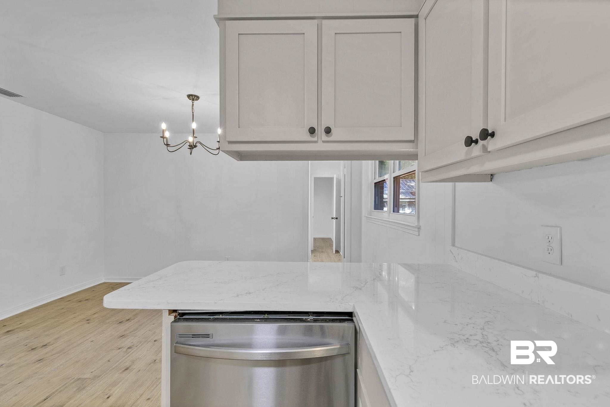 203 Anderson Road Saraland, AL 36571 - Photo 19 of 48 Kitchen featuring baseboards, light wood-type flooring, an inviting chandelier, light stone countertops, and dishwasher