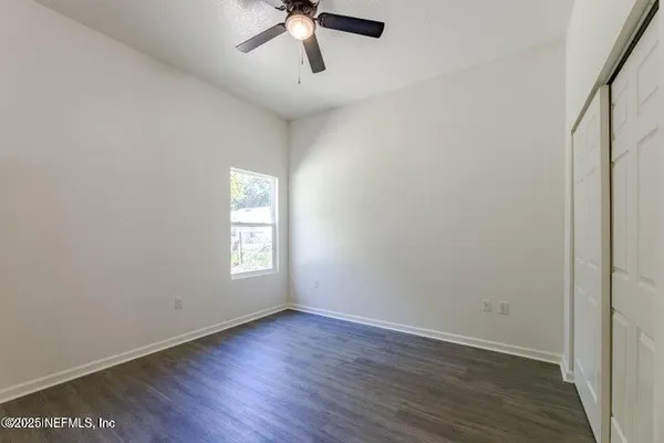 an empty room with wooden floor and window