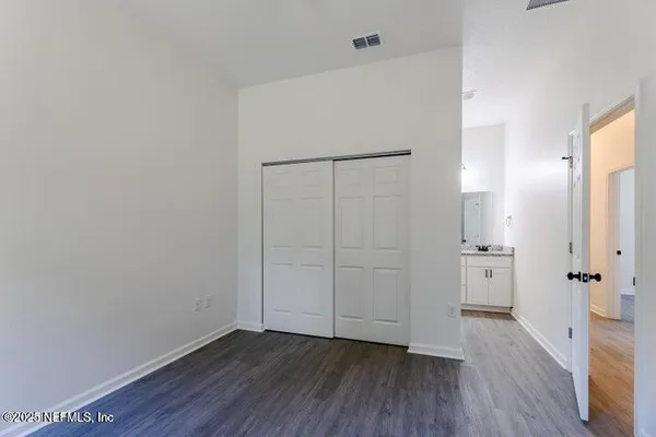 an empty room with wooden floor and mirror