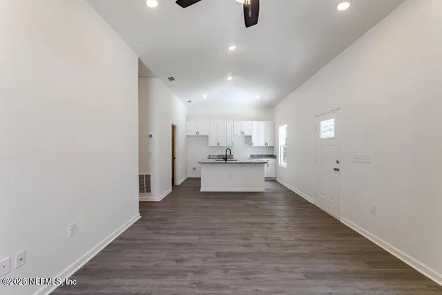 a view of a kitchen with a sink and wooden floor