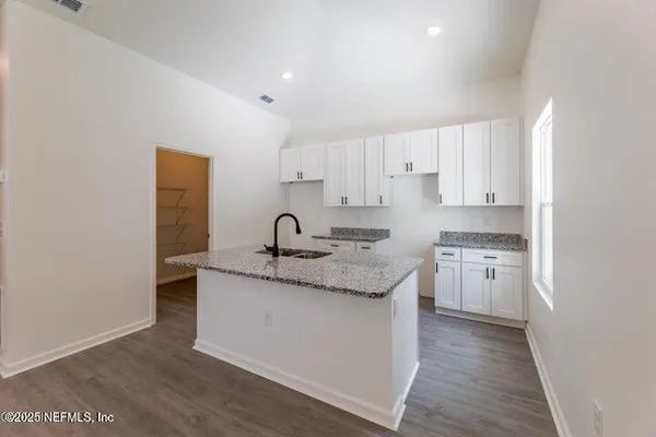 a kitchen with a sink stove and cabinets