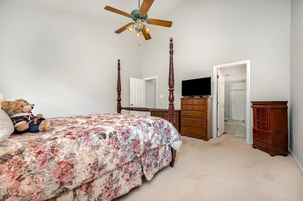 a bedroom with a bed dresser and a flat tv screen