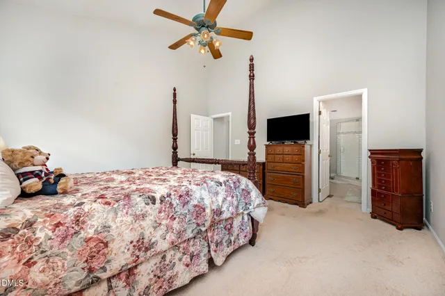 a bedroom with a bed dresser and a flat tv screen