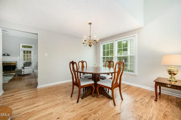 a dining room with furniture potted plants and wooden floor