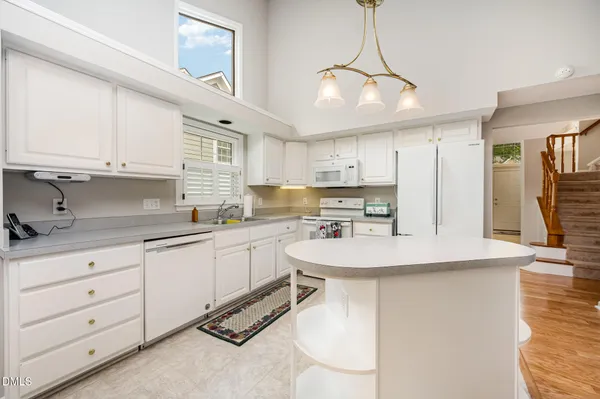 a kitchen with kitchen island granite countertop a sink a center island and cabinets