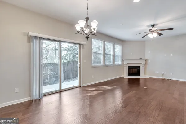 a view of an empty room with a fireplace and a window