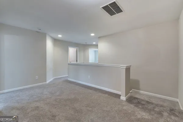 a view of an empty room with a kitchen