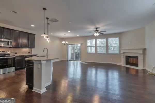 a view of an empty room with kitchen and a kitchen