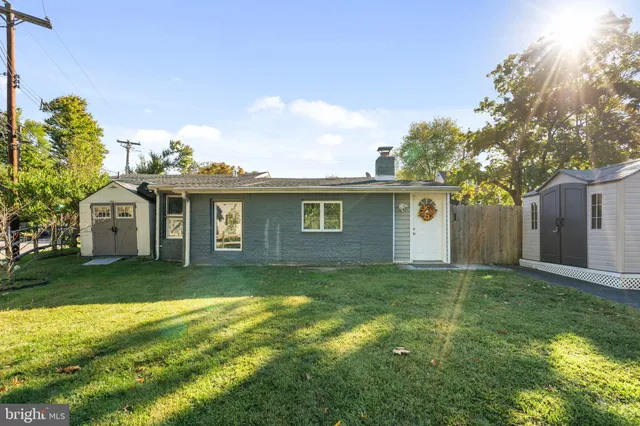 a view of a yard in front of a house with large trees