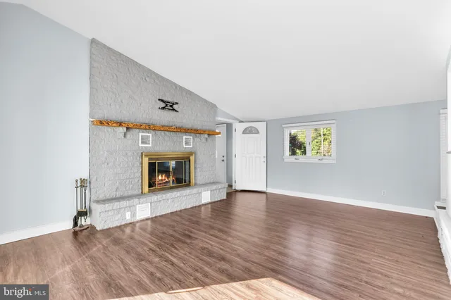 a view of a hallway with wooden floor and a living room