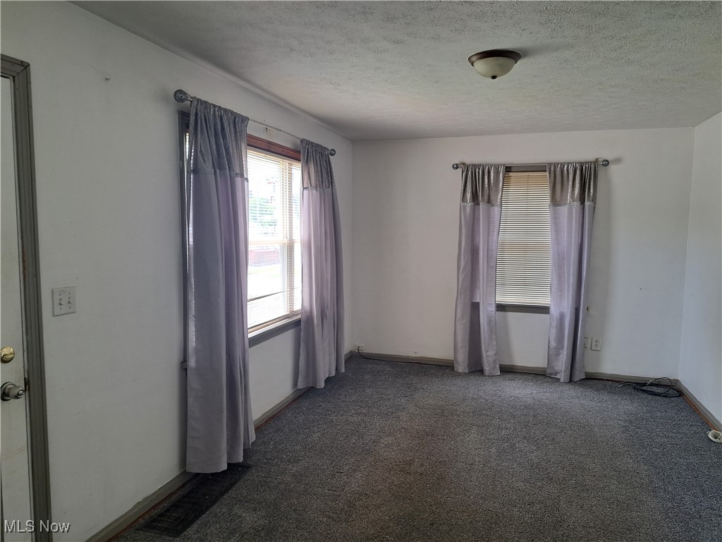 2239 North Ridge Road Lorain, OH 44055 - Photo 8 of 28 Empty room featuring carpet floors and a textured ceiling
