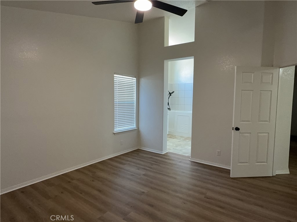 12590 Cobalt Road Victorville, CA 92392 - Photo 26 of 37 an empty room with wooden floor closet and chandelier fan