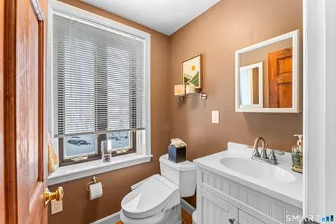 a bathroom with a sink a toilet and a window
