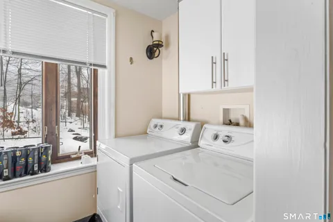 a view of washer and dryer with bathroom in the background