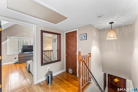 a view of a hallway with wooden floor and staircase