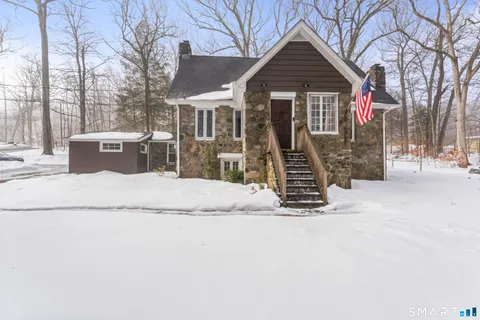 a view of a house with a yard covered in snow