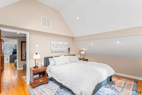 a bedroom with a bed and wooden floor