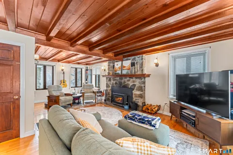 a living room with furniture a flat screen tv and a fireplace
