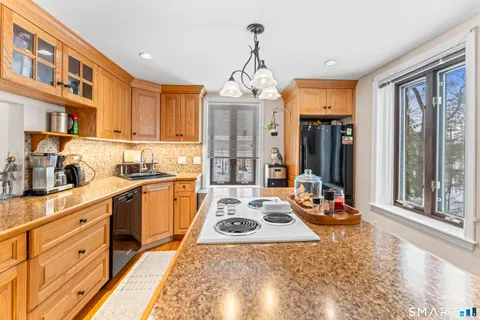 a kitchen with sink refrigerator and large window