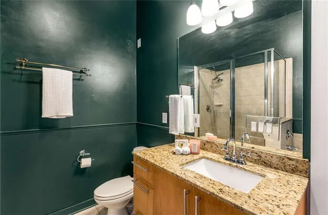 a view of a hallway with wooden floor and a bathroom