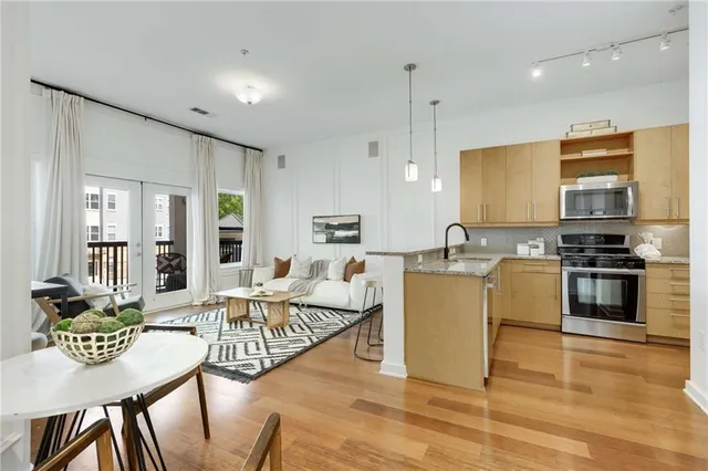 a living room with stainless steel appliances kitchen island granite countertop furniture and a view of kitchen