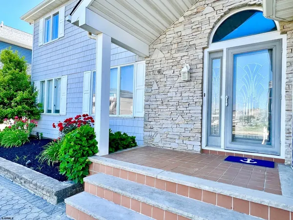 a front view of a house with a yard and flowers