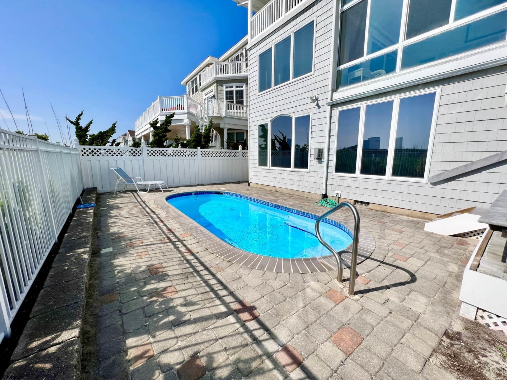 24 Ocean Drive West Brigantine, NJ 08203 - Photo 24 of 48 a view of a swimming pool with a lounge chairs