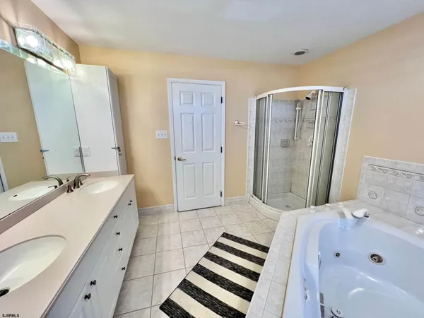 a bathroom with a tub sink and mirror