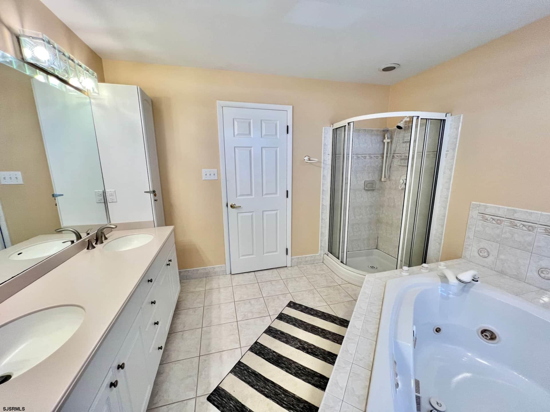 24 Ocean Drive West Brigantine, NJ 08203 - Photo 47 of 48 a bathroom with a tub sink and mirror