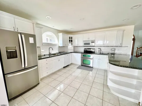 a kitchen with stainless steel appliances granite countertop a refrigerator sink and cabinets