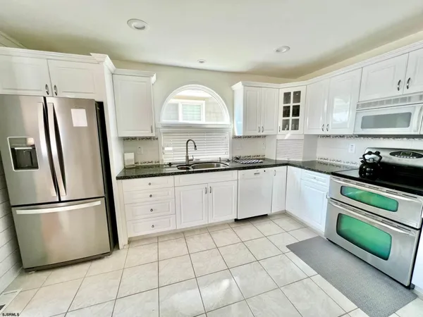 a kitchen with stainless steel appliances granite countertop a refrigerator sink and cabinets
