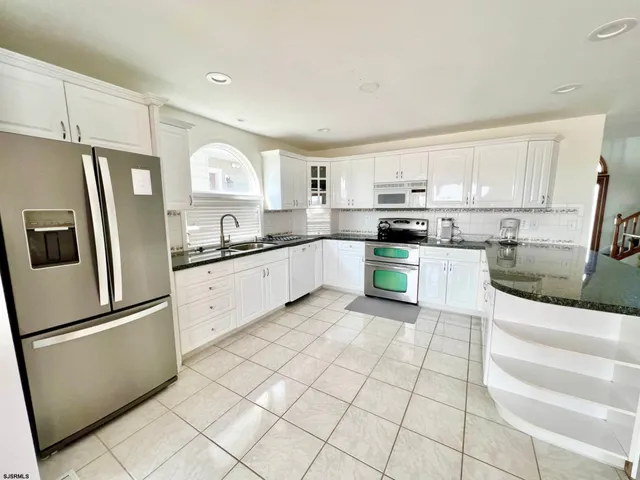a kitchen with stainless steel appliances granite countertop a refrigerator sink and cabinets