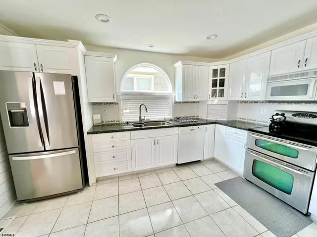 a kitchen with stainless steel appliances granite countertop a refrigerator sink and cabinets
