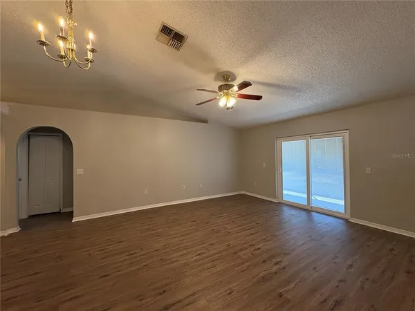 a spacious bedroom with a bed a couch and potted plant