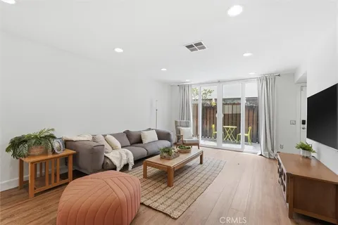a living room with furniture a flat screen tv and a floor to ceiling window