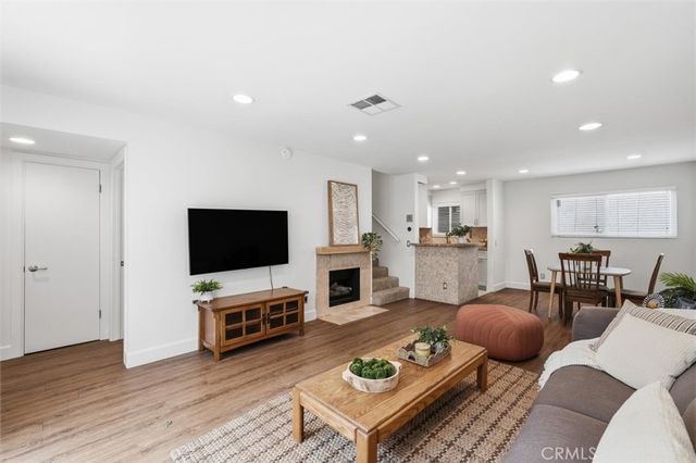 a living room with furniture a flat screen tv and kitchen view
