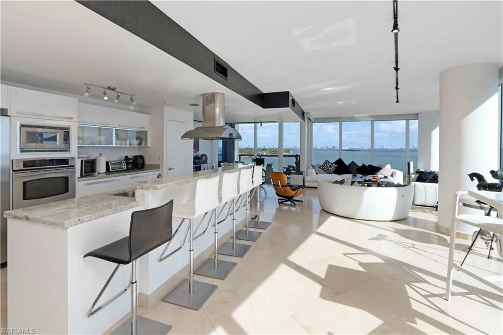 601 Northeast 36th Street, Unit 712 Miami, FL 33137 - Photo 16 of 28 a kitchen with stainless steel appliances kitchen island granite countertop a stove a sink a refrigerator and a cabinets