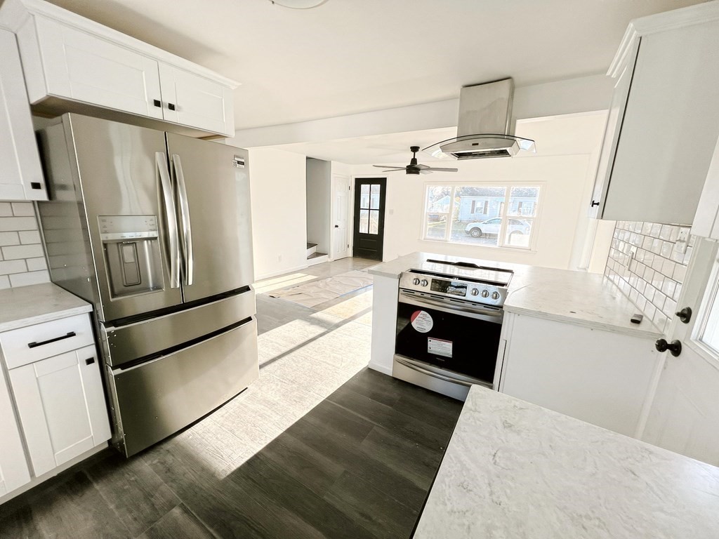 145 Powell Avenue Springfield, MA 01118 - Photo 4 of 10 a kitchen with stainless steel appliances and wooden floor