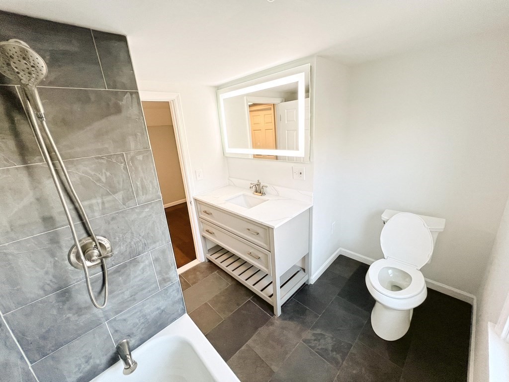 145 Powell Avenue Springfield, MA 01118 - Photo 5 of 10 a bathroom with a sink a toilet and mirror