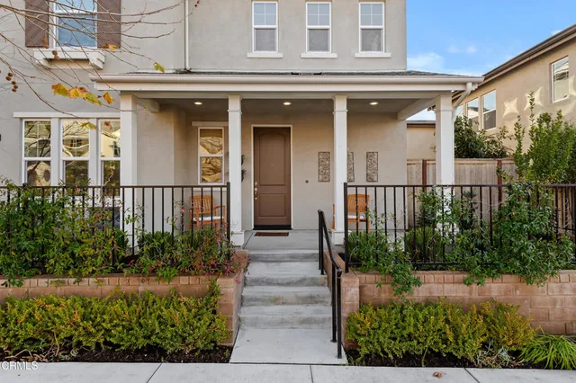 a front view of a house with plants and entryway