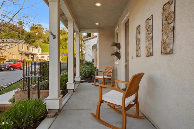 a porch with a table and chairs and potted plants