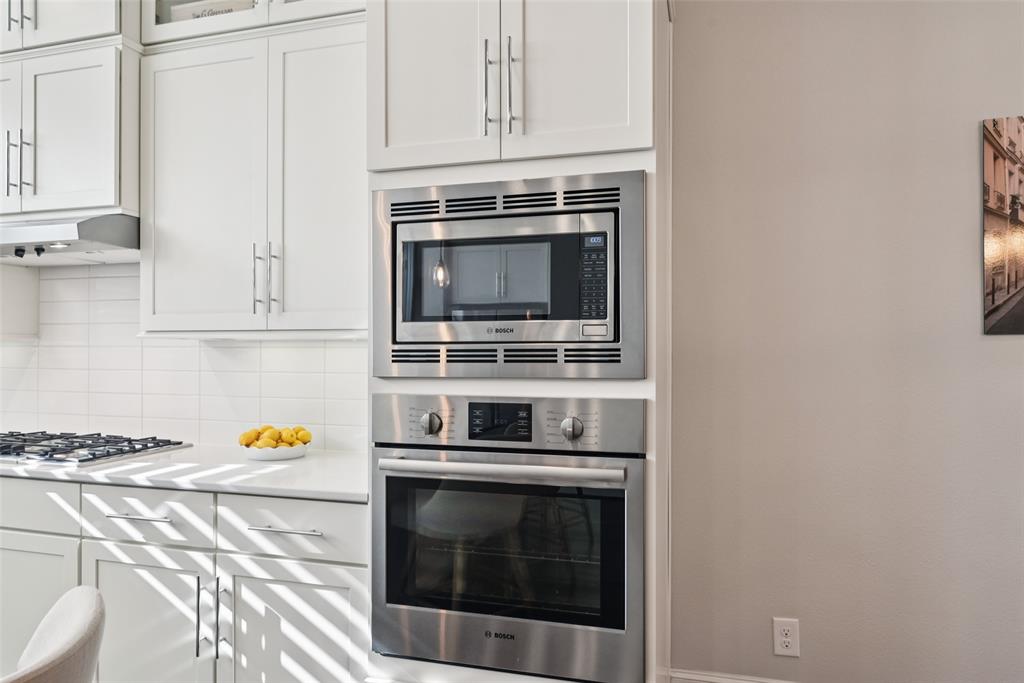 2815 Lynlock Court Dallas, TX 75219 - Photo 14 of 39 a kitchen with stainless steel appliances a stove and white cabinets