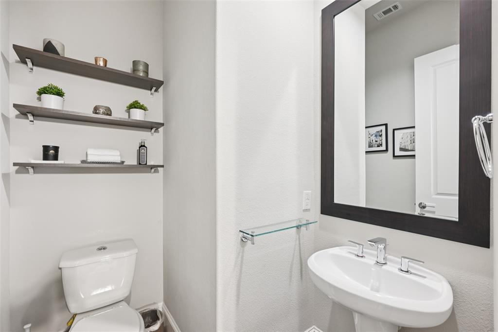 2815 Lynlock Court Dallas, TX 75219 - Photo 15 of 39 a bathroom with a toilet sink and mirror
