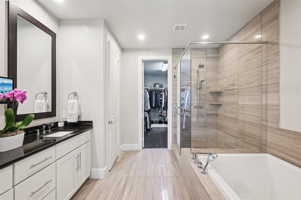 2815 Lynlock Court Dallas, TX 75219 - Photo 19 of 39 a bathroom with a granite countertop sink a mirror and a shower