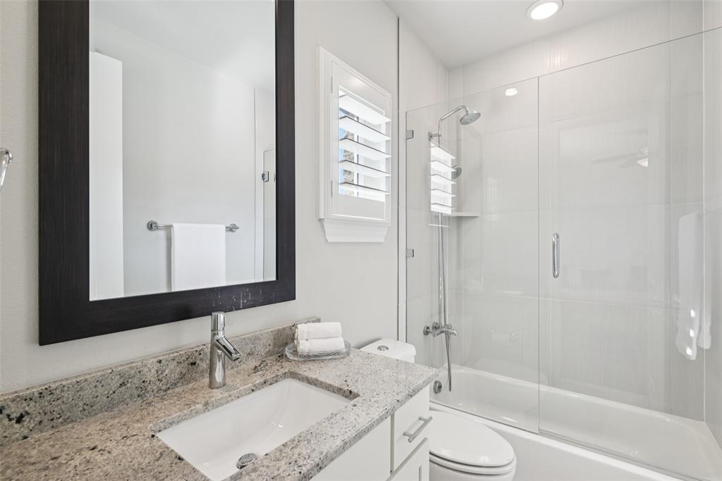 2815 Lynlock Court Dallas, TX 75219 - Photo 26 of 39 a bathroom with a granite countertop sink toilet and shower