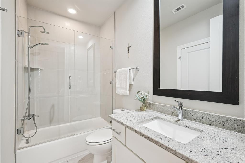 2815 Lynlock Court Dallas, TX 75219 - Photo 32 of 39 a bathroom with a granite countertop sink toilet and shower